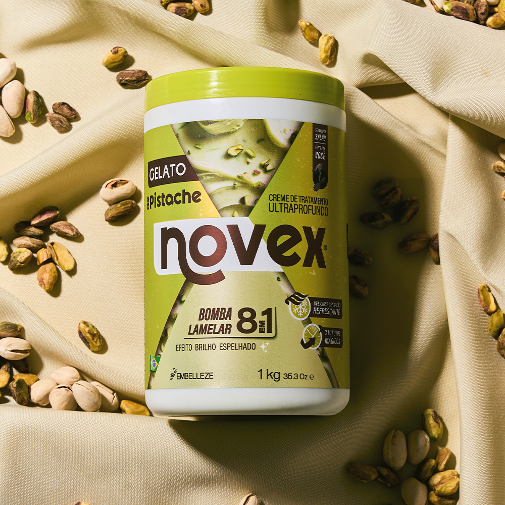 Creme de tratamento ultraprofundo Novex Gelato de Pistache da Embelleze de 1kg, com ação bomba lamelar 8 em 1 e efeito brilho espelhado, posicionado sobre um tecido claro texturizado com pistaches espalhados ao redor.