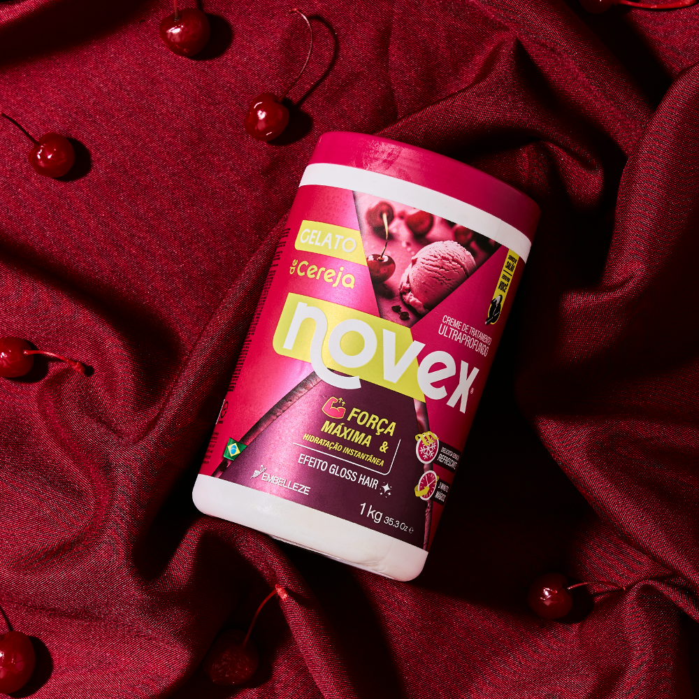 Creme de tratamento ultraprofundo Novex Gelato de Cereja da Embelleze de 1kg, com ação de força máxima e hidratação instantânea, posicionado sobre um tecido vermelho texturizado com cerejas espalhadas ao redor.