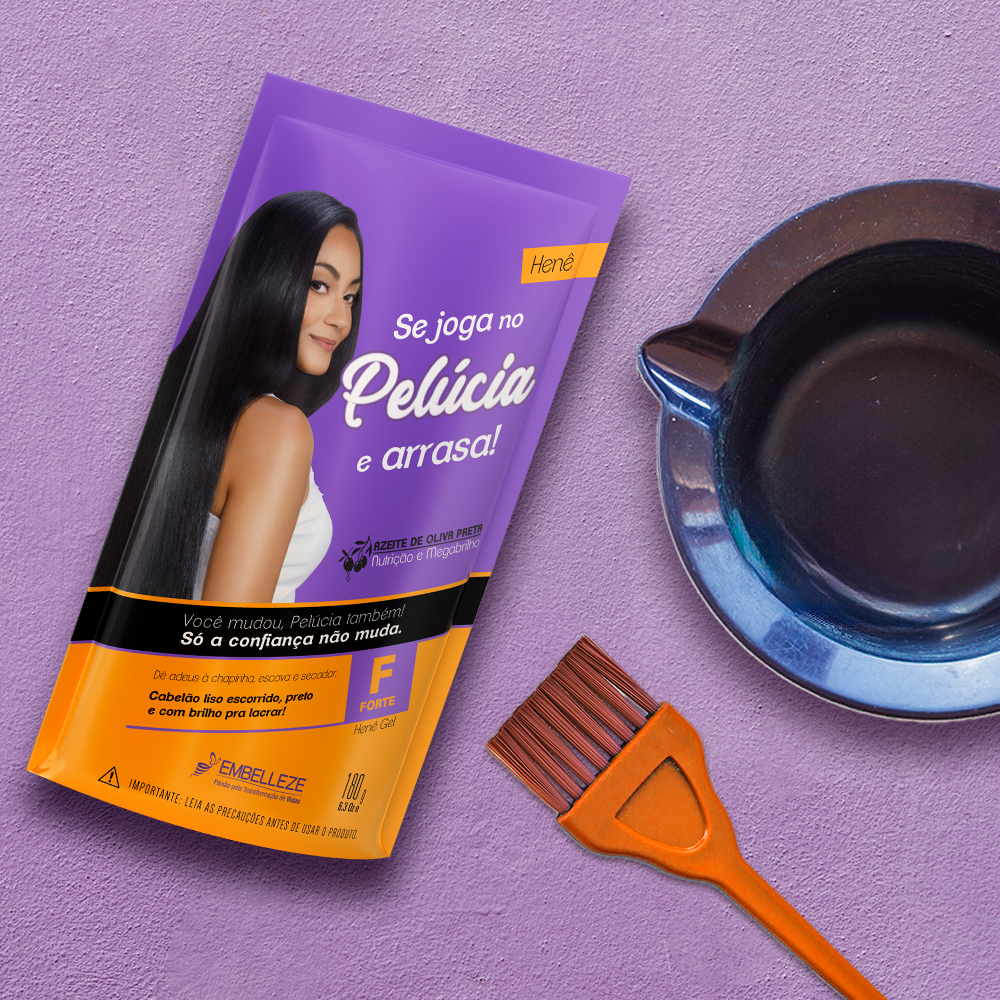 Sachê de Henê Gel Pelúcia Forte Embelleze de 180g para alisamento e tintura preta, posicionado ao lado de um pincel aplicador laranja e uma tigela plástica sobre fundo texturizado lilás.